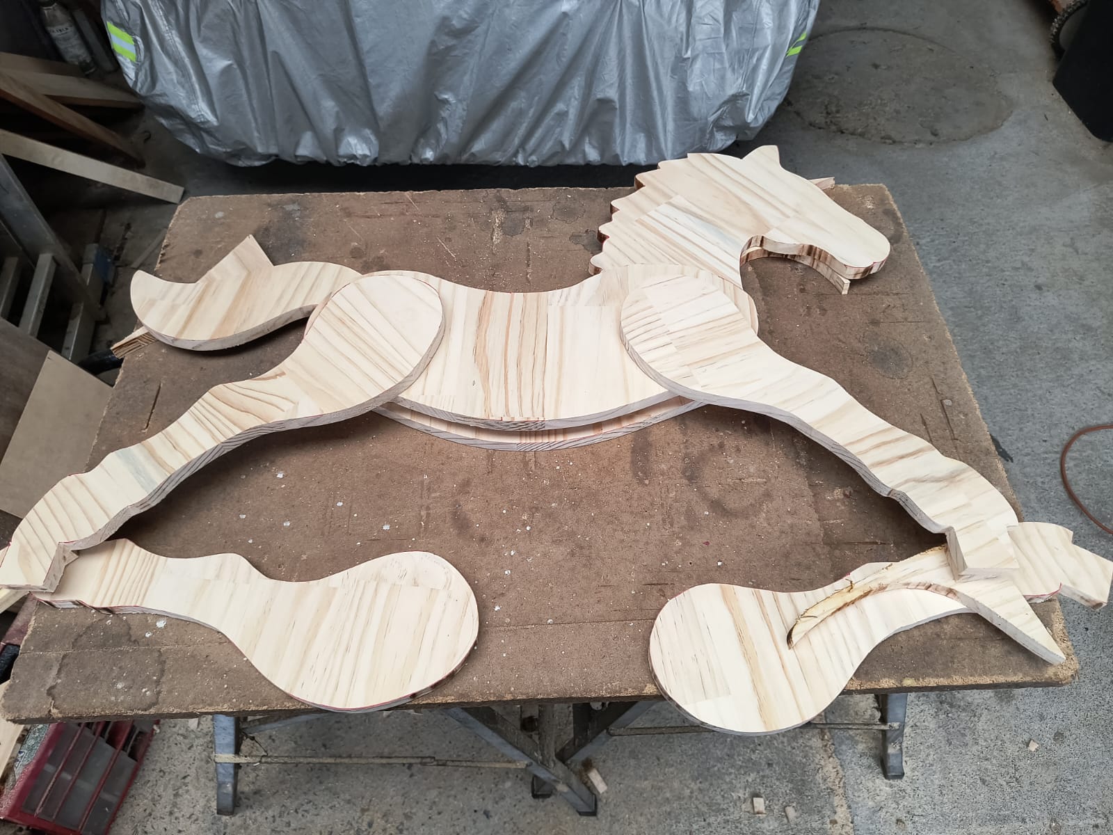 Piezas del caballo balancín recién cortadas en el taller